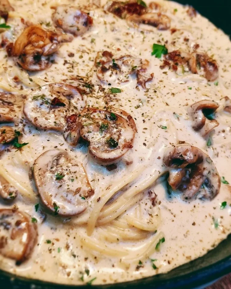 Creamy mushroom pasta dish garnished with parsley on a white plate