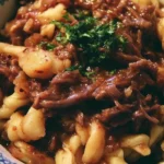 Crock Pot Mississippi Beef Noodles served in a bowl with fresh herbs