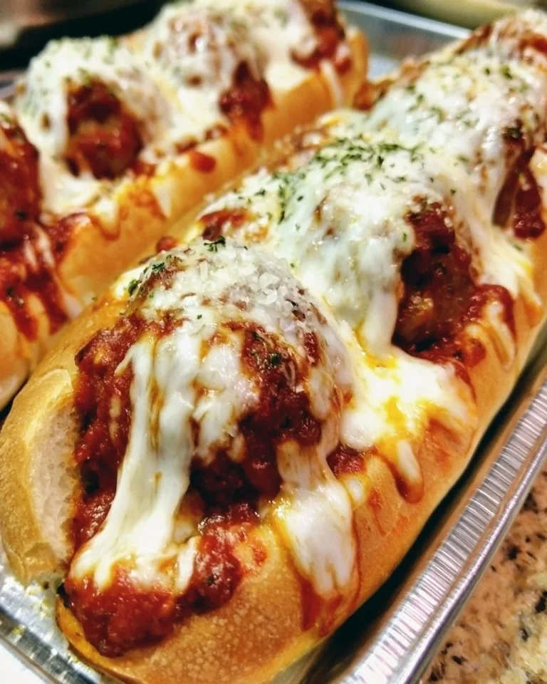 Delicious oven-baked meatball sandwiches topped with cheese and herbs